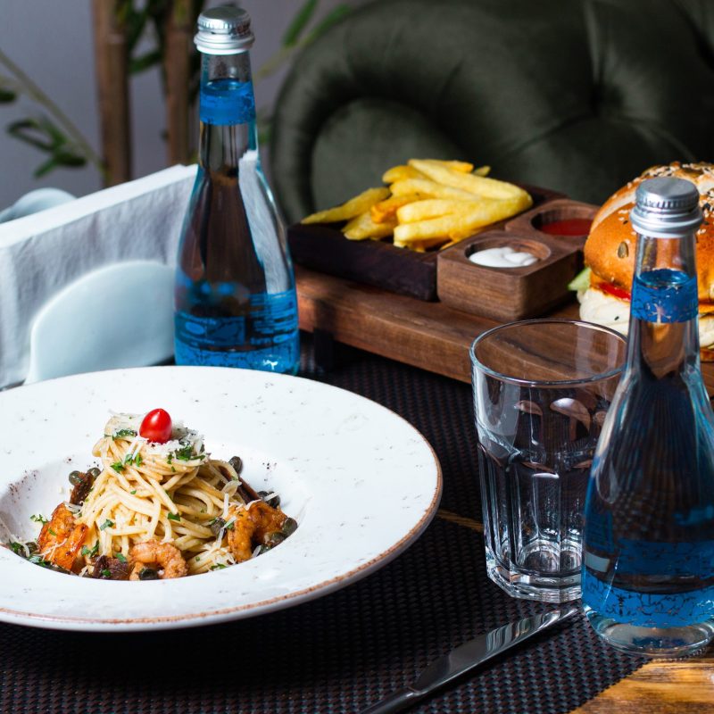 pasta with shrimps grated cheese greens and cherry tomato on top
